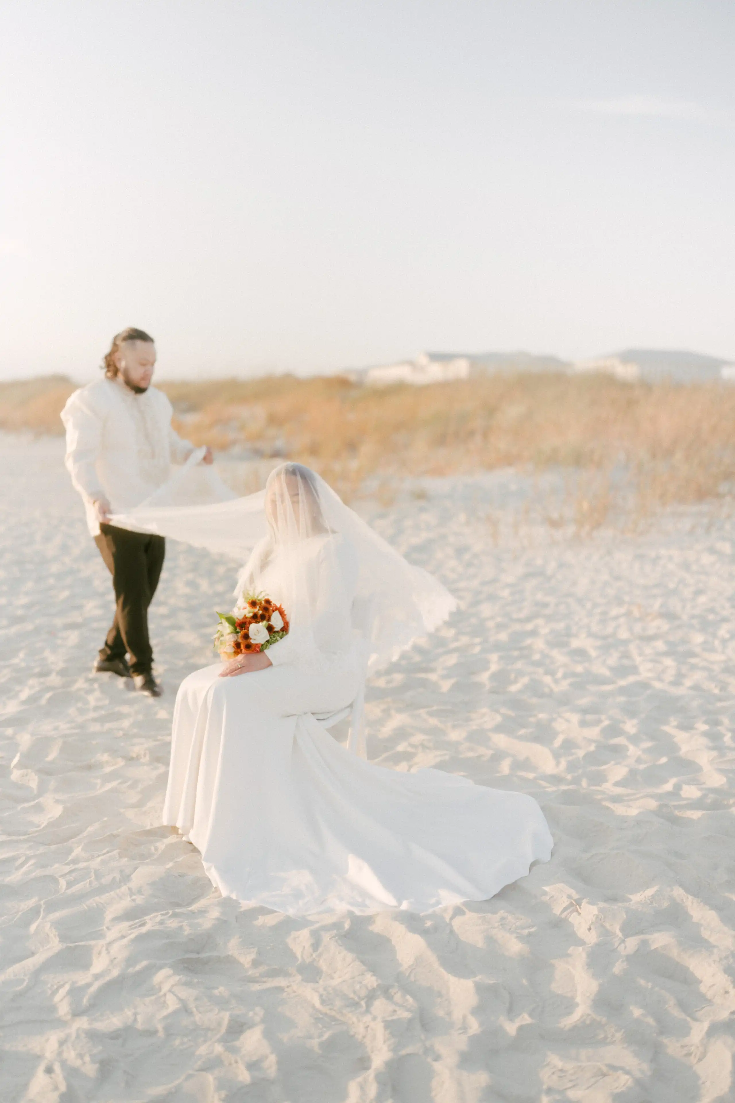 Happy couple embracing and smiling together at the beach during sunset.