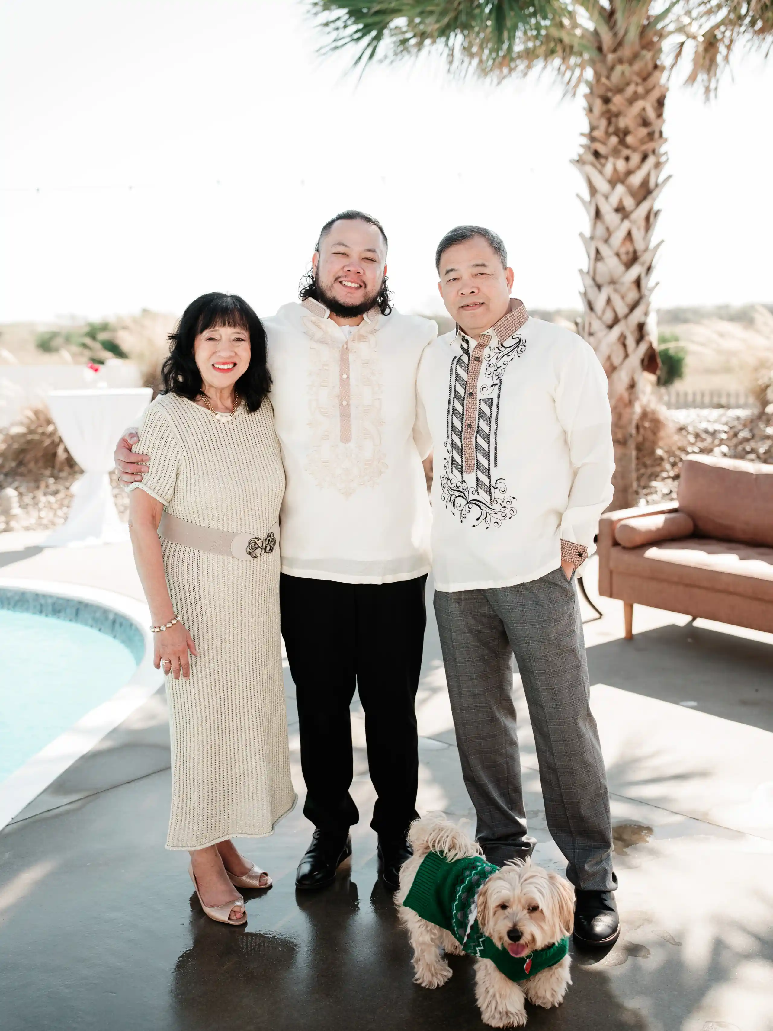 Portrait of someone in a blue button-down shirt against a green foliage background.